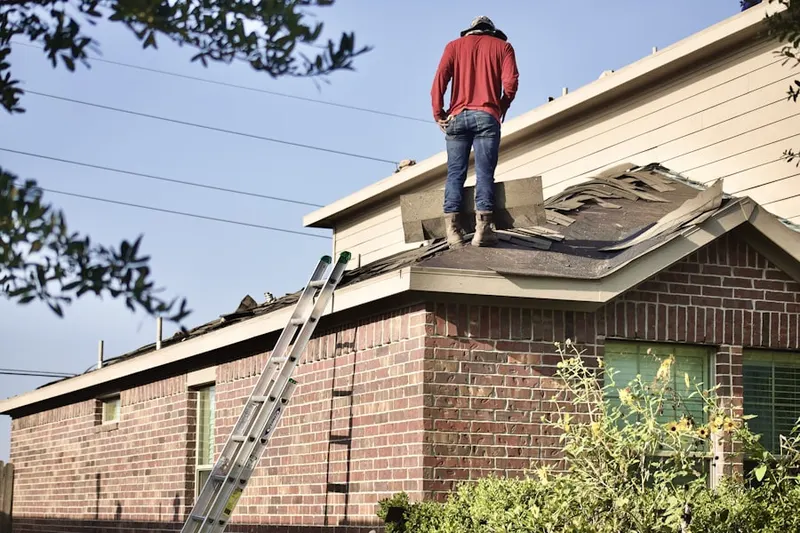 Professional roofer working on a residential roof in Newfields